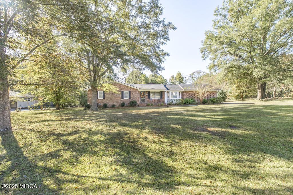 559 Stone Edge Road Macon, GA 31210 - Photo 2 of 40 a view of a house with a big yard and large trees