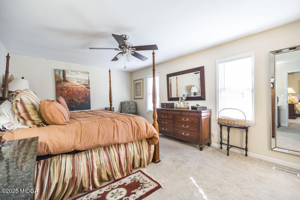 559 Stone Edge Road Macon, GA 31210 - Photo 27 of 40 a bedroom with a large bed and a chandelier
