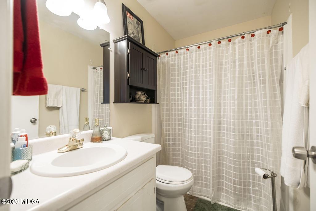 559 Stone Edge Road Macon, GA 31210 - Photo 31 of 40 a bathroom with a sink a toilet and shower curtain