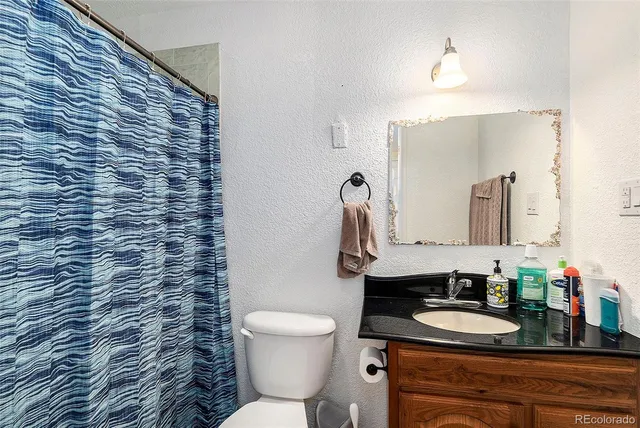 a bathroom with a toilet sink and mirror