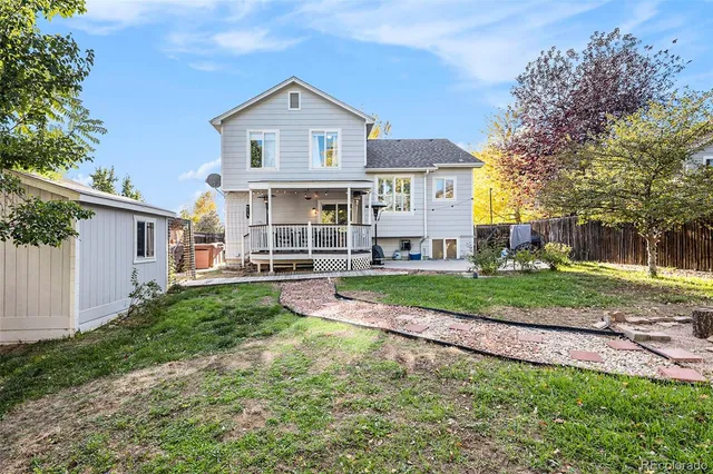 a view of a house with a big yard plants and large trees