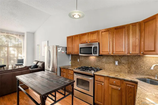 a kitchen with stainless steel appliances granite countertop a stove refrigerator sink and cabinets