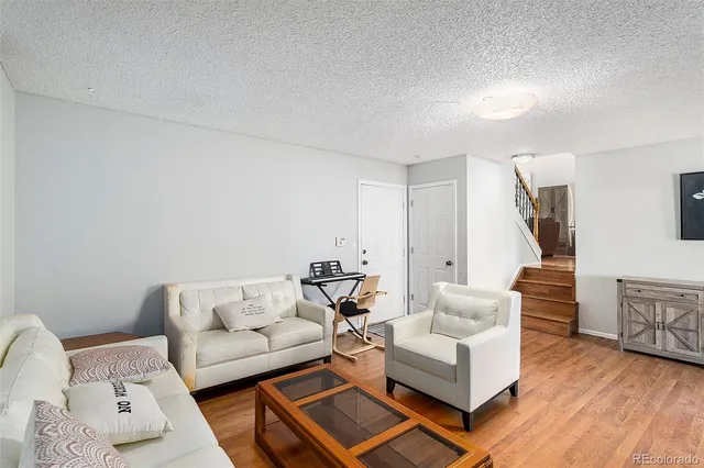 a living room with furniture and wooden floor