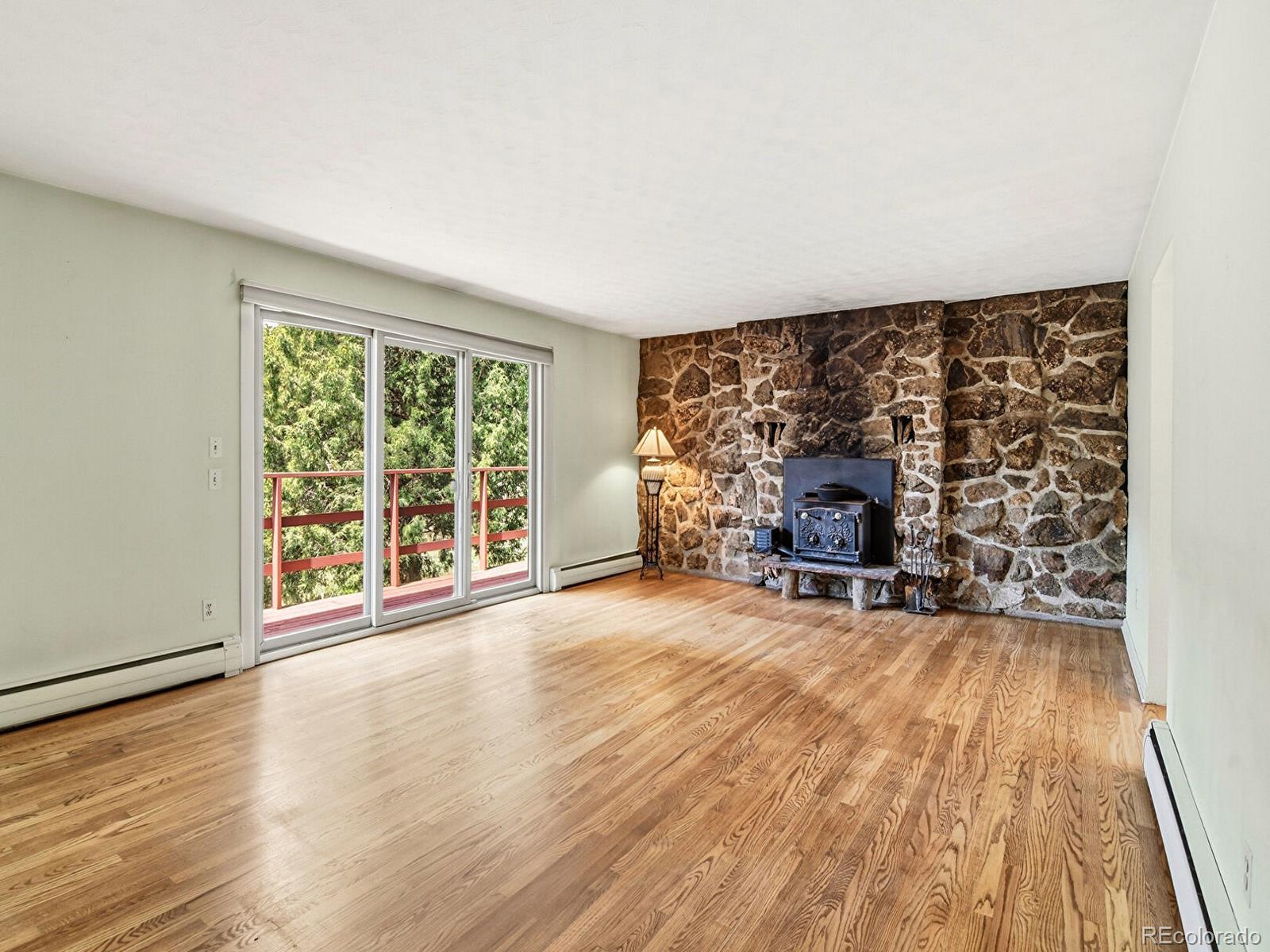 2830 Kerr Gulch Road Evergreen, CO 80439 - Photo 13 of 48 a view of an empty room with a fireplace and a large window