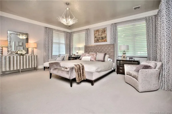 a spacious bedroom with a bed and a couch with window