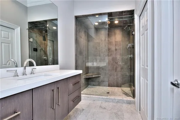 a bathroom with a shower sink and mirror