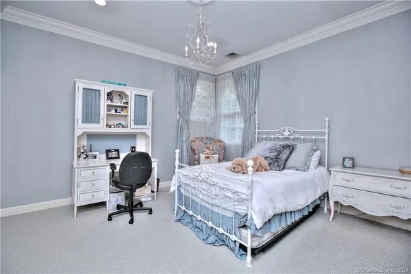 a bedroom with a bed and a chandelier