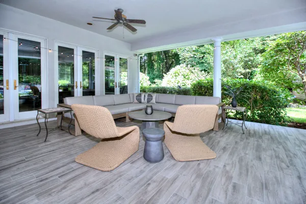 a living room with patio furniture and a wooden floor