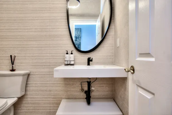 a bathroom with a sink a mirror and a lamp