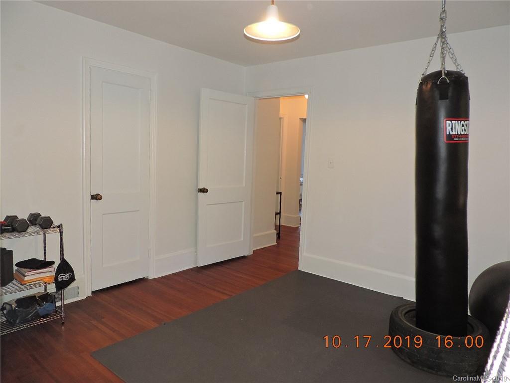 5908 Tuckaseegee Road Charlotte, NC 28208 - Photo 22 of 30 a view of a room with wooden floor and a ceiling fan