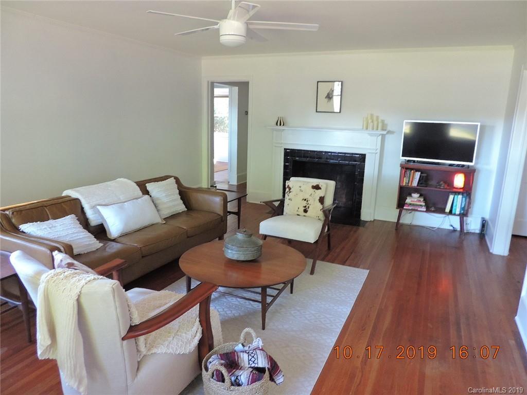 5908 Tuckaseegee Road Charlotte, NC 28208 - Photo 4 of 30 a living room with furniture a fireplace and wooden floor