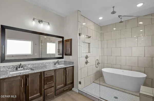 a bathroom with a granite countertop sink a toilet a mirror and bathtub