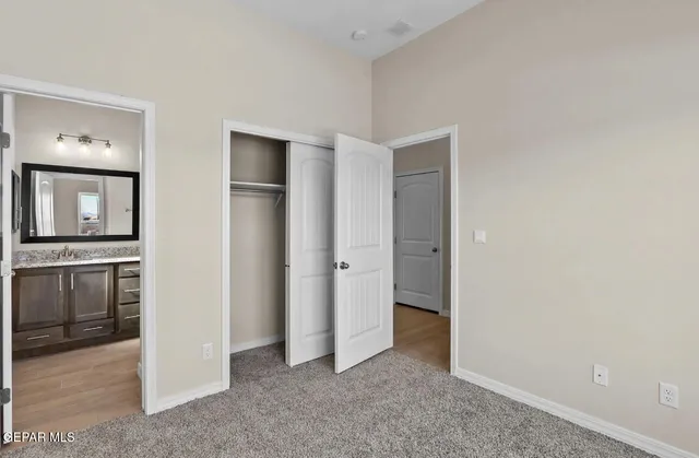 an empty room with closet and windows