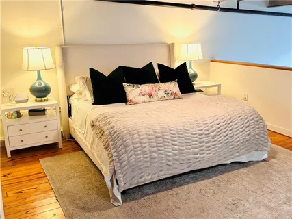 a large bed sitting in a bedroom next to a window