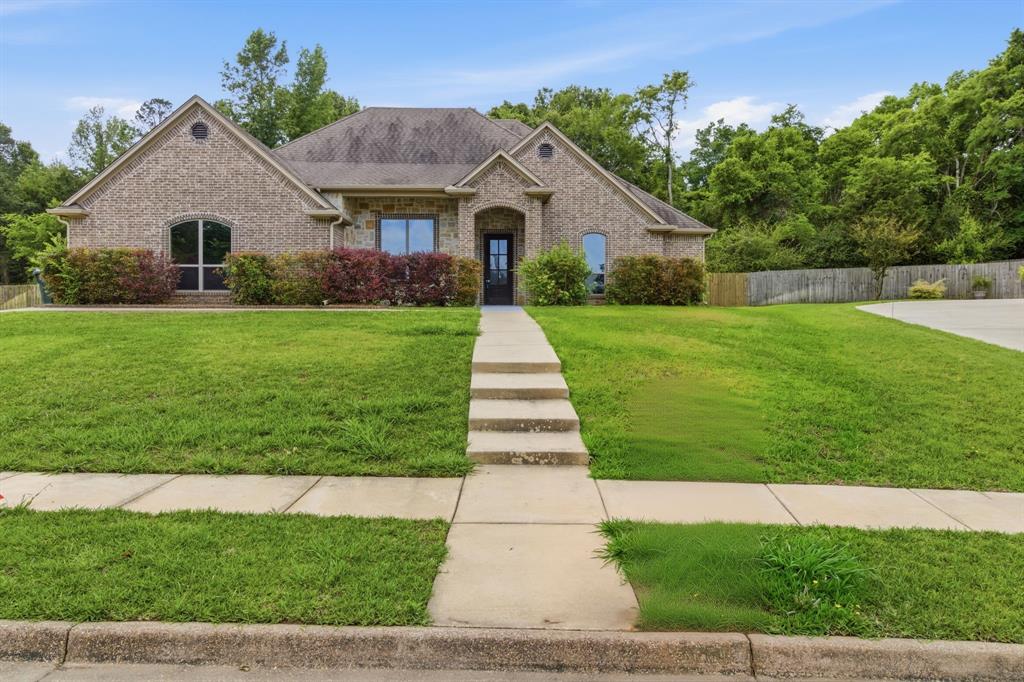 7765 Hickory Spring Lane Tyler, TX 75703 - Photo 2 of 38 Brick exterior with gabled roofline, arched windows, and a multi-level concrete walkway