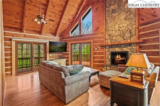 a living room with furniture a fireplace and wooden floor
