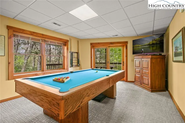 a room with pool table and windows
