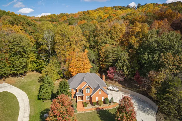 an aerial view of a house with a yard and lake view