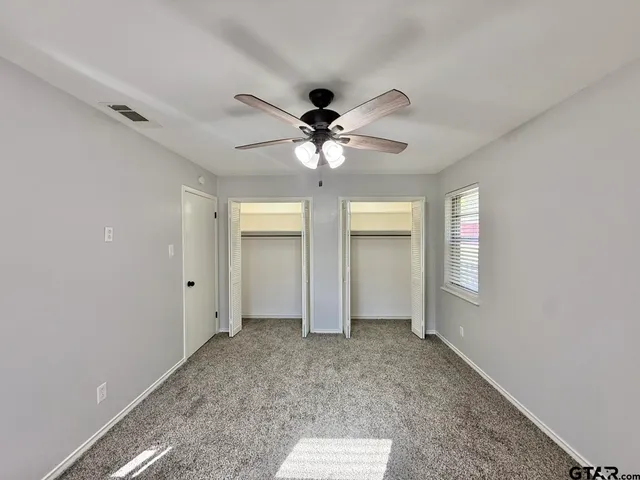 a view of an empty room with a ceiling fan