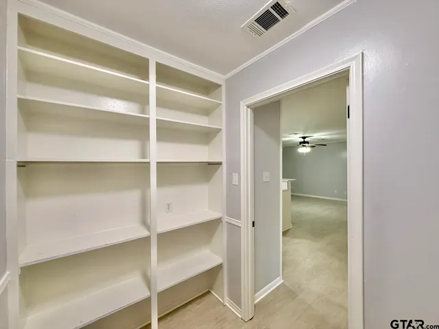 a view of walk in closet with empty racks