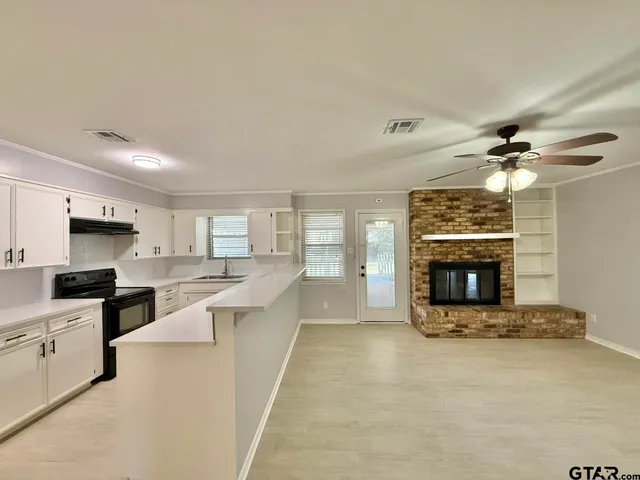 a large kitchen with a stove and a fireplace