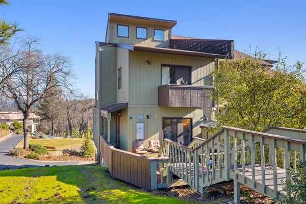 a view of a house with wooden fence and a porch