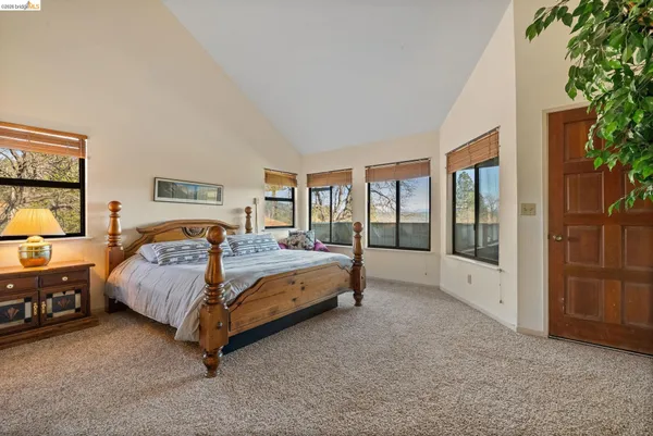 a bed sitting in a spacious bedroom next to a window