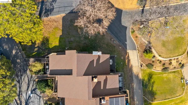 an aerial view of residential house with outdoor space and trees all around