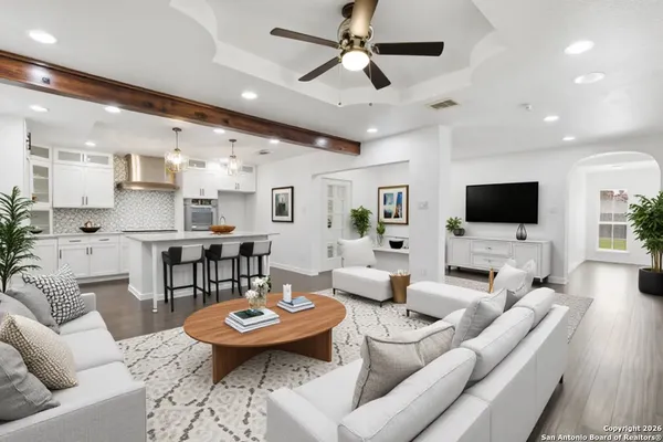 a living room with furniture kitchen view and a flat screen tv