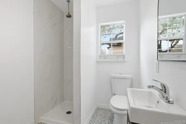 a bathroom with a sink toilet and shower