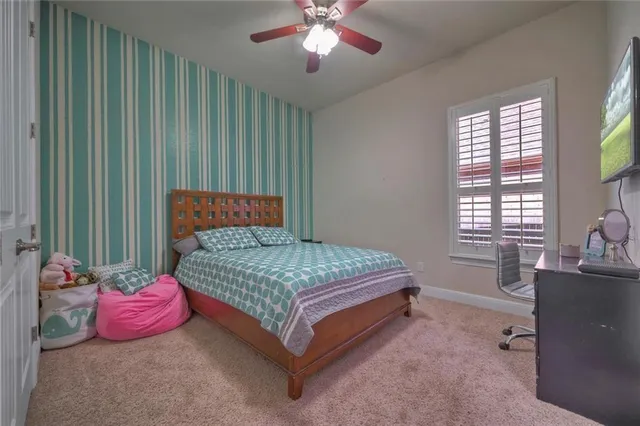 a bedroom with a bed and a flat tv screen on dresser