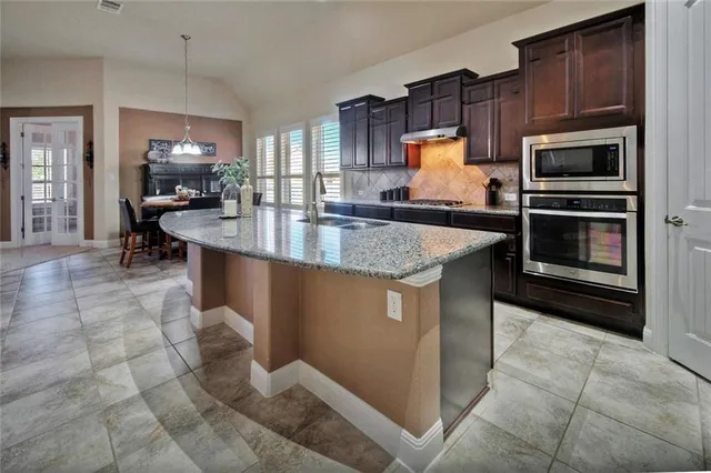 a large kitchen with stainless steel appliances lots of counter top space