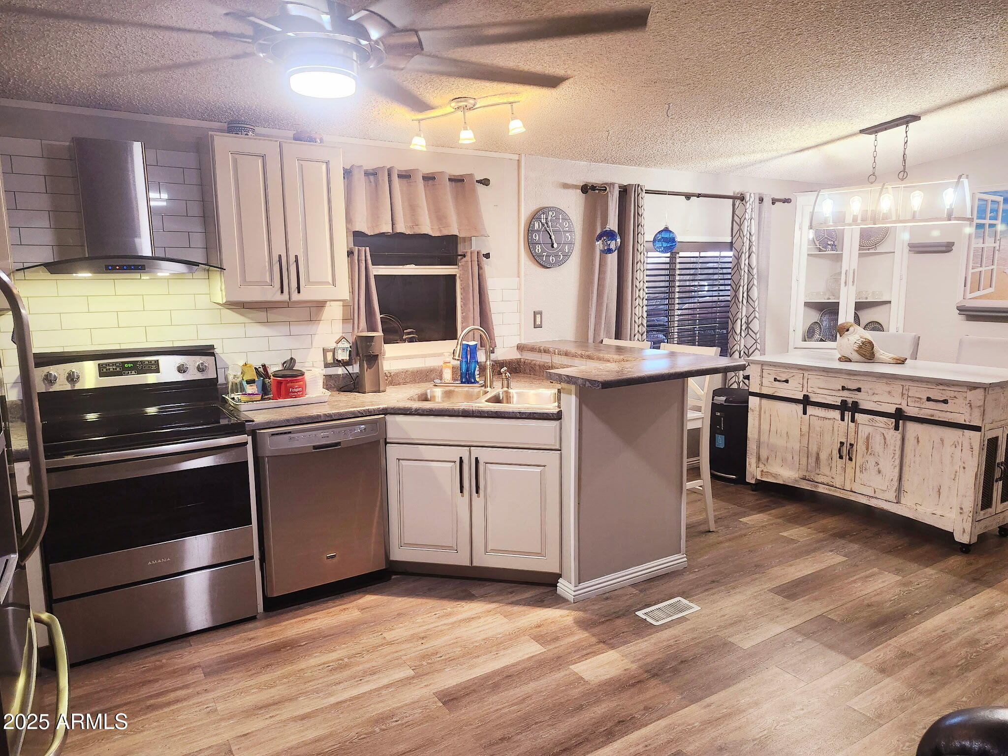 3700 South Tomahawk Road, Unit 18 Apache Junction, AZ 85119 - Photo 4 of 21 a kitchen with stainless steel appliances granite countertop a stove and white cabinets