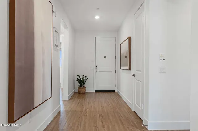 a view of a hallway with wooden floor