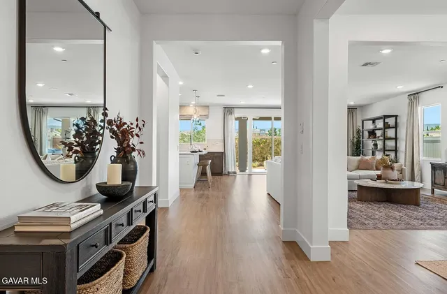 a view of a hallway with dining room and wooden floor