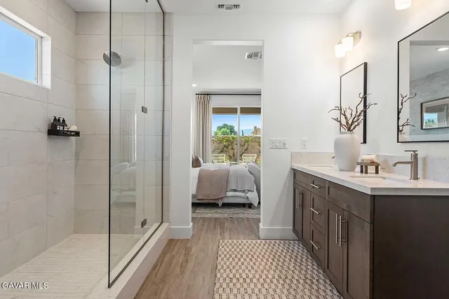 a en suite bathroom with a sink a mirror and a shower