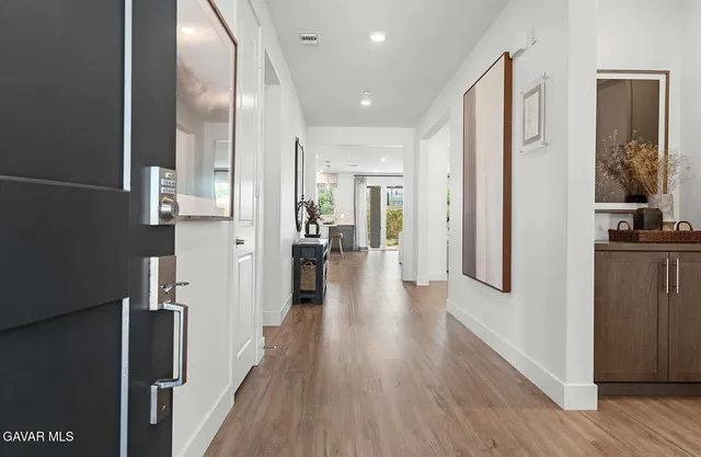 a view of a hallway with wooden floor windows and livingroom