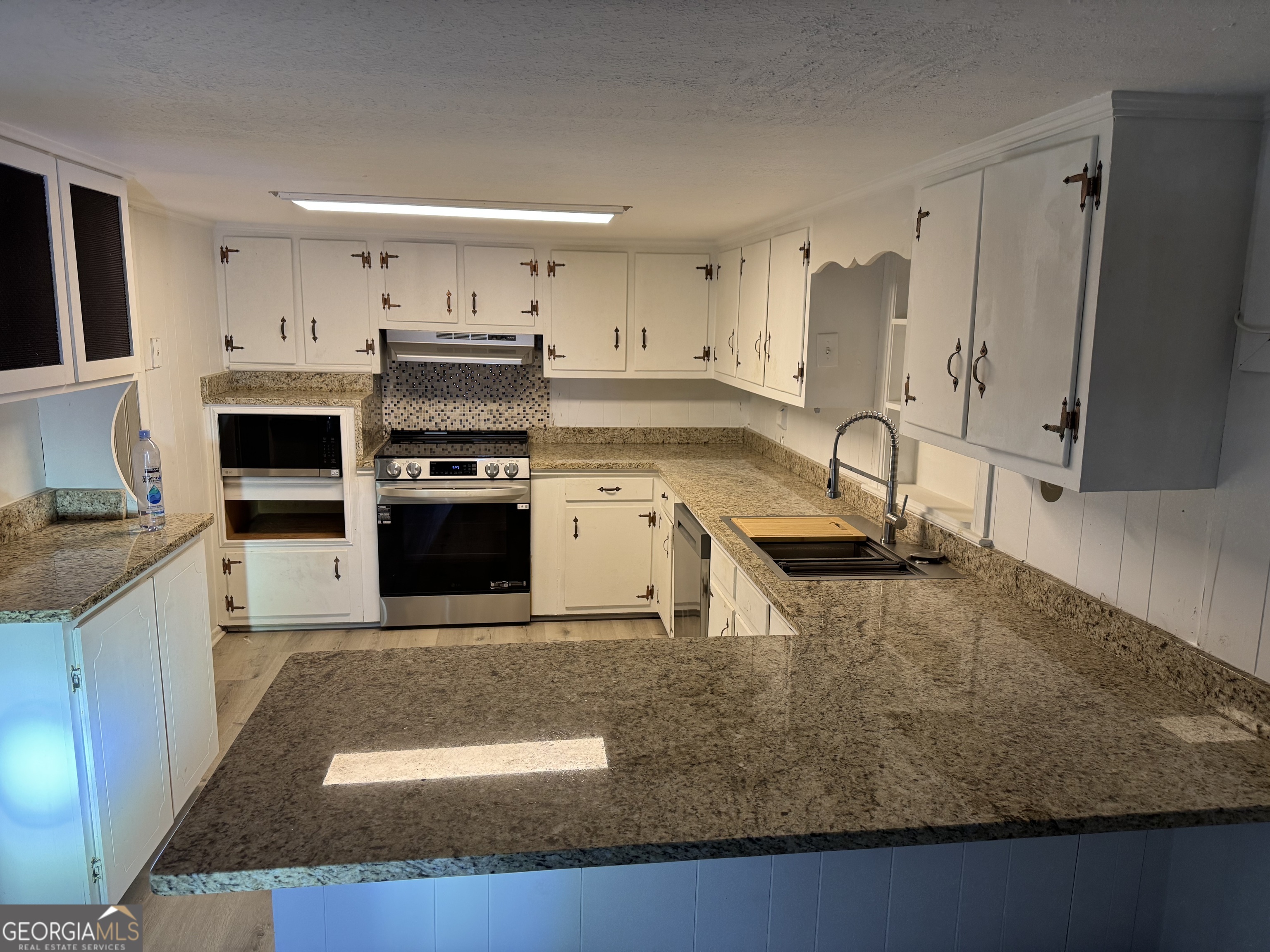 2363 Alvin Joiner Road Dublin, GA 31021 - Photo 30 of 35 a kitchen with stainless steel appliances granite countertop a sink a stove and a refrigerator