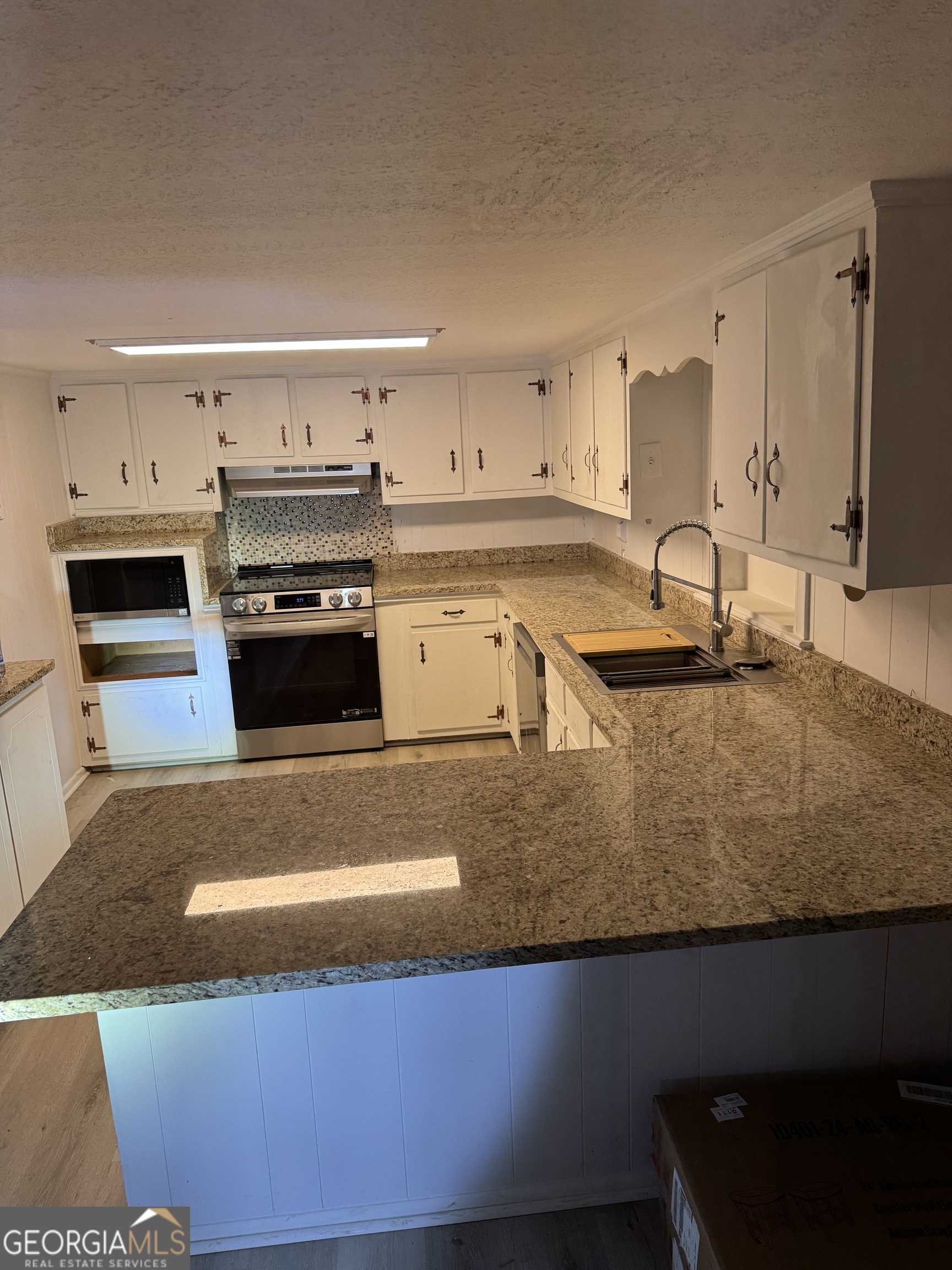 2363 Alvin Joiner Road Dublin, GA 31021 - Photo 32 of 35 a kitchen with stainless steel appliances granite countertop a sink a stove and a refrigerator
