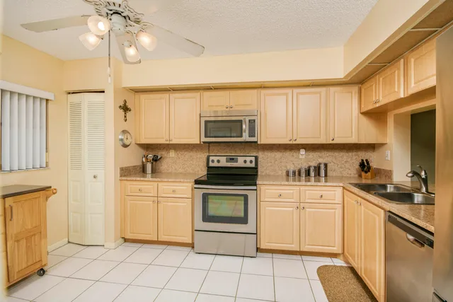 a kitchen with white cabinets and appliances