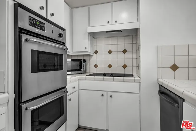 a kitchen with appliances cabinets and a stove top oven
