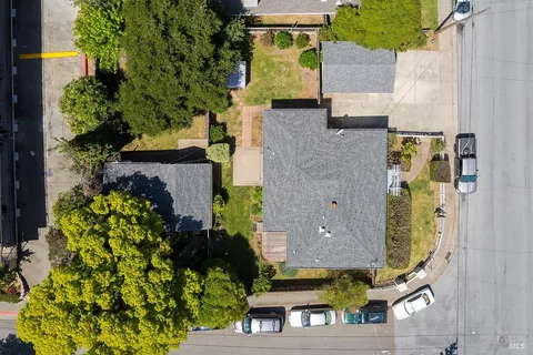 an aerial view of residential houses with outdoor space and parking