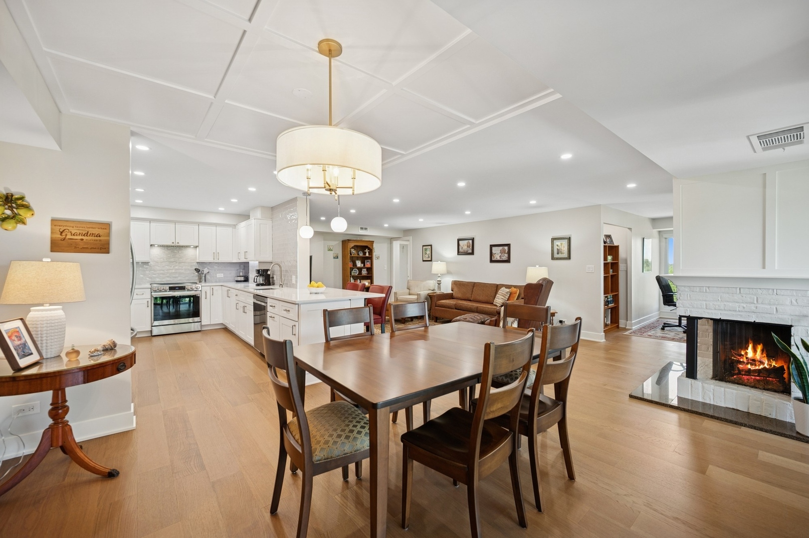 3801 Mission Hills Road, Unit 510 Northbrook, IL 60062 - Photo 6 of 19 a dining room with kitchen island furniture a fireplace and a chandelier