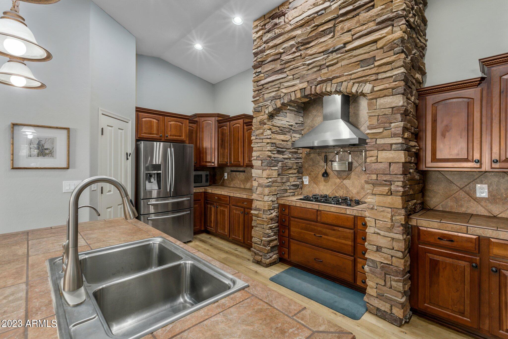 4565 East Ruffian Road Gilbert, AZ 85297 - Photo 11 of 47 a kitchen with stainless steel appliances granite countertop a sink and a stove