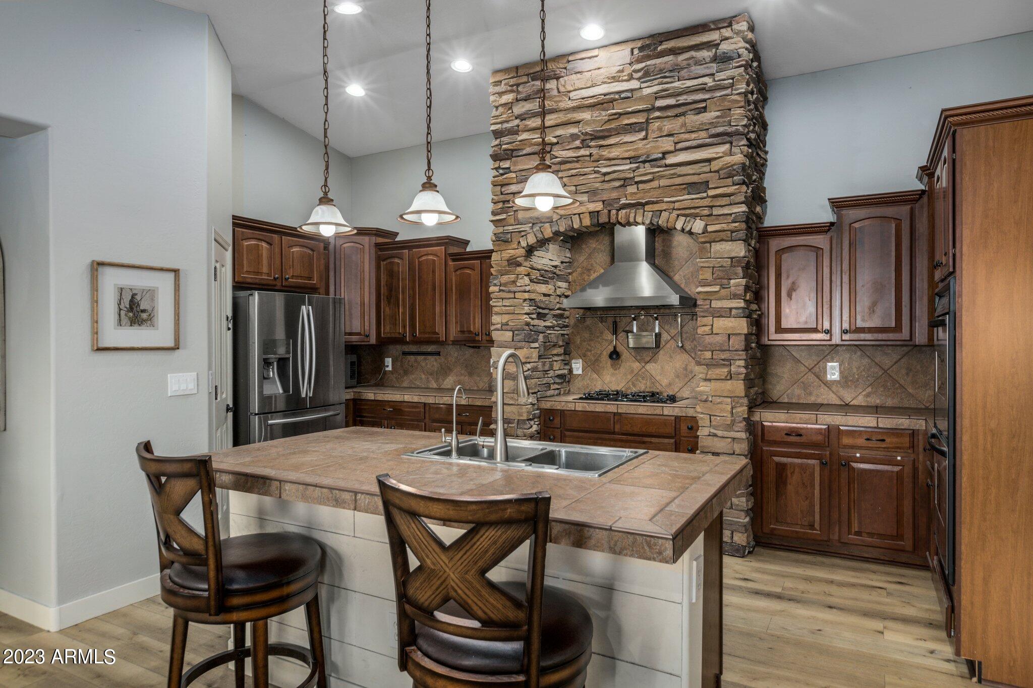 4565 East Ruffian Road Gilbert, AZ 85297 - Photo 12 of 47 a kitchen with stainless steel appliances kitchen island a table and chairs in it