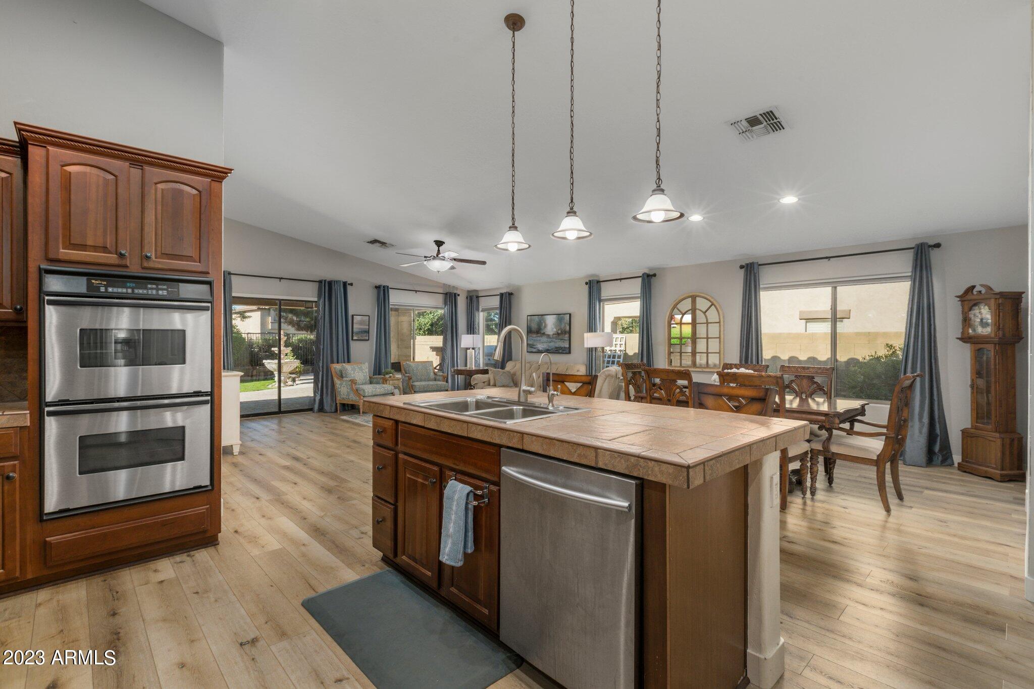4565 East Ruffian Road Gilbert, AZ 85297 - Photo 15 of 47 a kitchen with kitchen island a sink and a stove top oven