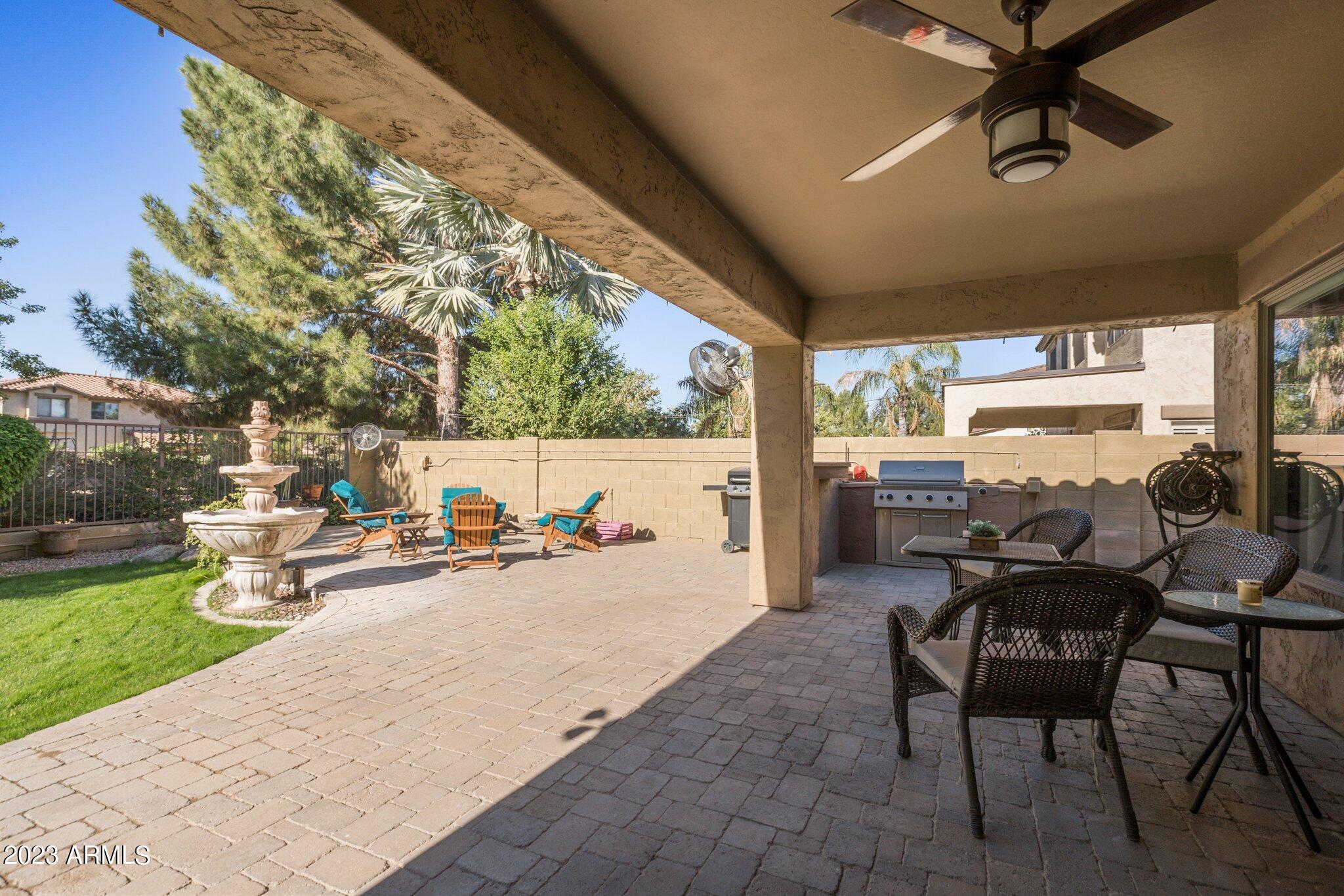 4565 East Ruffian Road Gilbert, AZ 85297 - Photo 25 of 47 a view of a patio with table and chairs and couches with wooden floor and fence