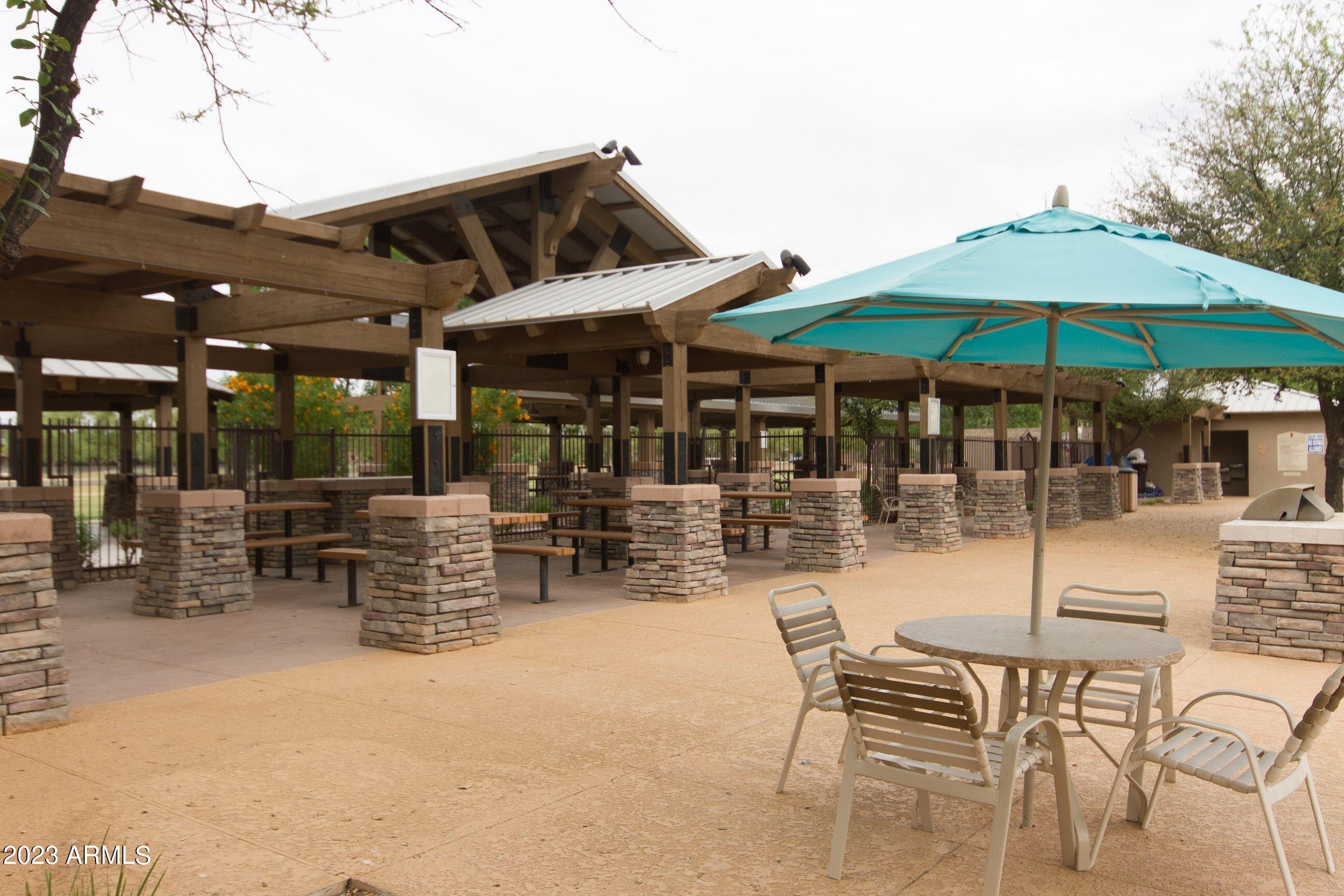 4565 East Ruffian Road Gilbert, AZ 85297 - Photo 32 of 47 a view of a patio with a table and chairs under an umbrella