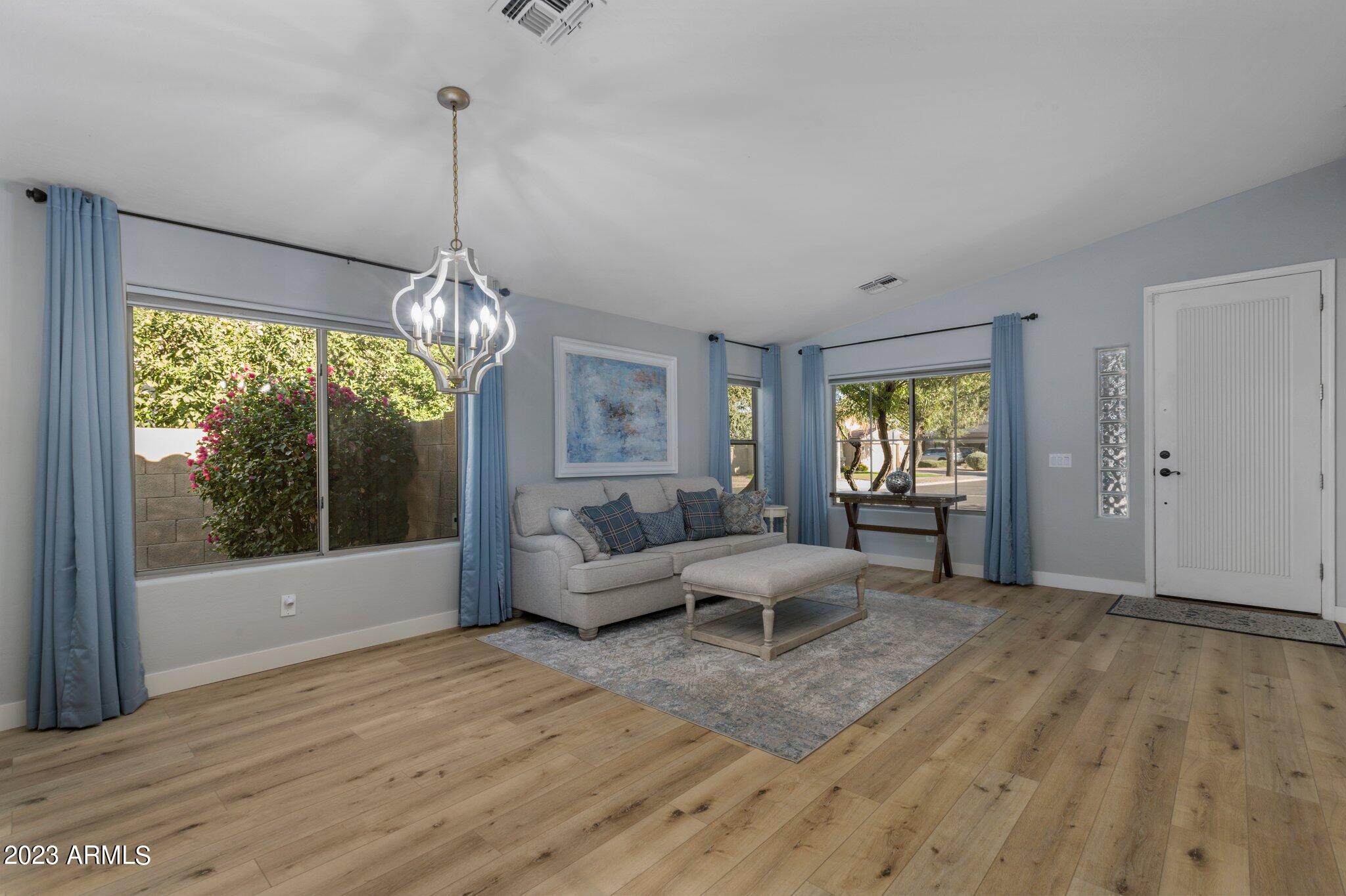 4565 East Ruffian Road Gilbert, AZ 85297 - Photo 5 of 47 a living room with furniture and a chandelier