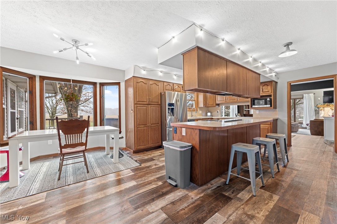 645 Killinger Road Clinton, OH 44216 - Photo 7 of 50 Kitchen featuring a textured ceiling, dark wood-type flooring, stainless steel refrigerator with ice dispenser, and built in microwave